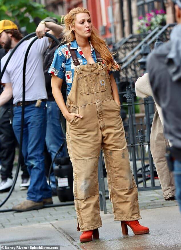 IMG_5151 Blake Lively wearing a patchwork shirt under tan carhart overalls with red platform heeled boots as Lily Bloom in movie adaptation of Colleen Hoover's book "It Ends with Us"